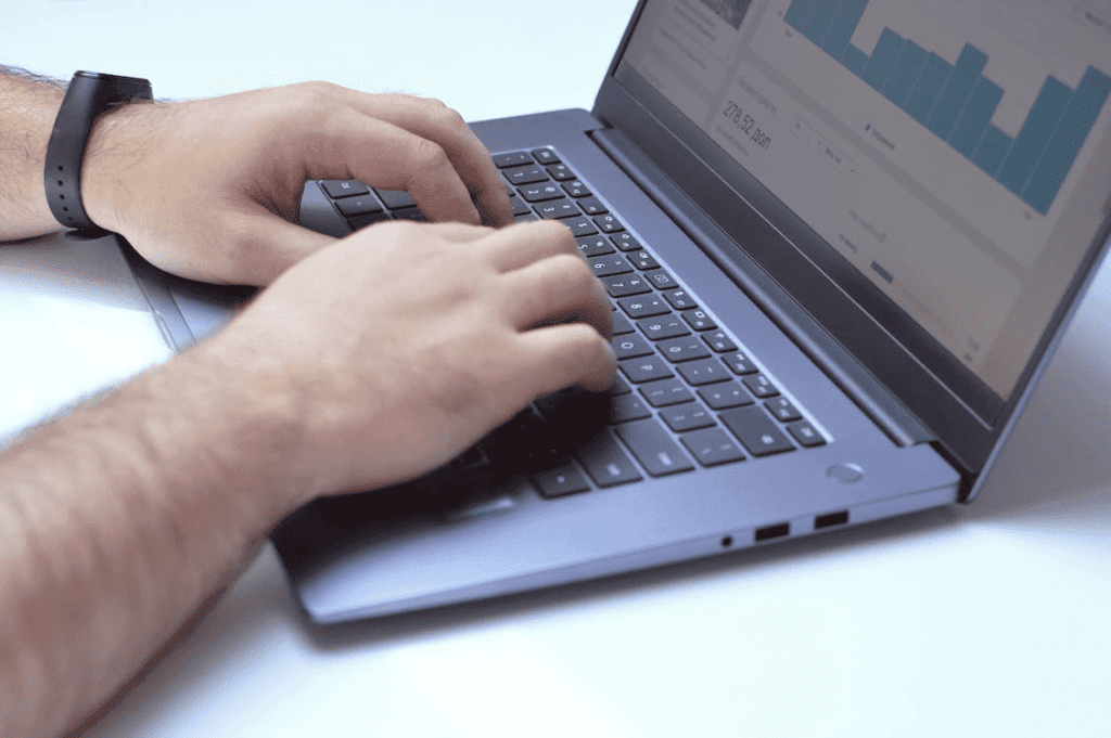 A person typing on a laptop with a graph displayed on the screen and using the ahrefs plugin for WordPress.